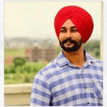 a man wearing a red turban and a plaid shirt .