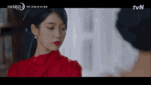 a woman in a red dress is looking at another woman in a tvn advertisement