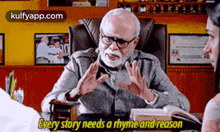 a man with glasses and a beard is sitting at a desk talking to a woman while holding a book .