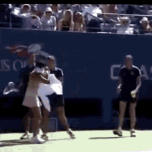 a group of people are playing tennis on a court with a sign that says us open in the background