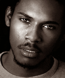 a close up of a man 's face with a tear running down his face