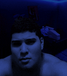 a man without a shirt is looking at the camera in a dark room