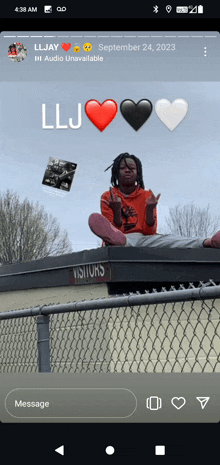 a person sitting on top of a chain link fence with a sign that says visitors on it