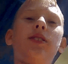 a close up of a boy 's face with a missing tooth .