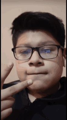 a young boy wearing glasses is making a funny face