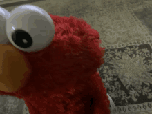 a red elmo stuffed animal with big white eyes