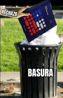 a person throwing a book into a trash can with the word basura written on it