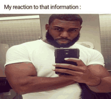 a man with a beard is taking a selfie in a bathroom with the caption " my reaction to that information "