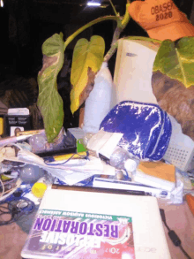 an acer laptop sits on a messy desk next to a book called restoration explosive