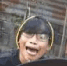 a man wearing glasses and a hat is making a funny face while riding a roller coaster .