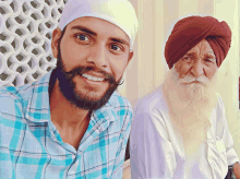 a man with a beard and a turban smiles next to another man