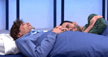 two men are laying on a bed holding hands and smiling