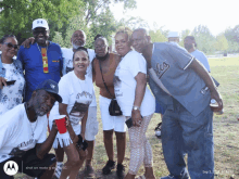 a group of people posing for a photo with one man wearing a baltimore orioles jersey