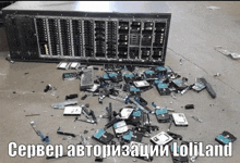 a bunch of hard drives are laying on the ground with a server in the background