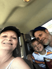 a man and woman are posing for a picture in a car with a boy