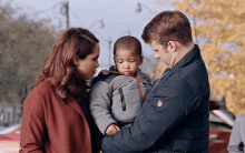 a man and a woman holding a baby with a caption that says ' chicagotimes '