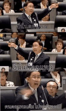 a man in a suit and tie is giving a speech in front of a crowd in a foreign language