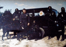 a group of soldiers are posing for a picture in front of a vehicle with the letter u on it