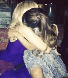 two women hugging each other in a room .