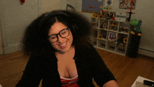 a woman wearing headphones and glasses is smiling in front of a shelf with a minecraft sign on it