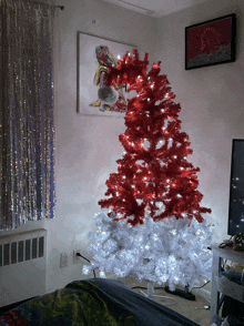 a red and white christmas tree with white lights