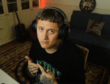 a man wearing headphones is sitting in front of a couch with a pillow that says fonbet on it