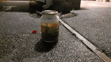 a jar of baby food sits on the sidewalk