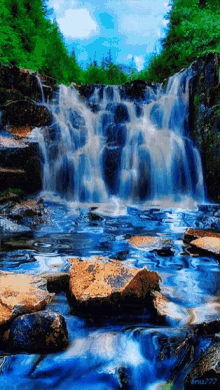 a painting of a waterfall with a blue sky and trees in the background has a watermark on the bottom right