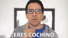 a man wearing glasses and a gray hoodie says " eres cochino "