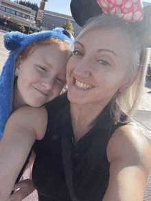 a woman and a child wearing mickey mouse ears