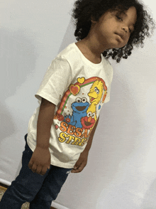 a young boy wearing a sesame street shirt