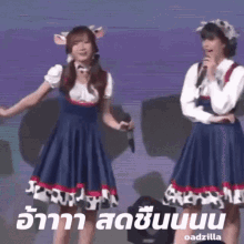 two girls wearing cow ears are dancing and singing into microphones