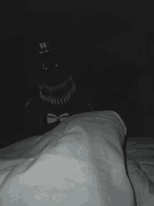 a black and white photo of a monster in a top hat and bow tie on a bed