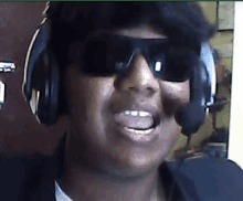 a man wearing sunglasses and headphones is smiling