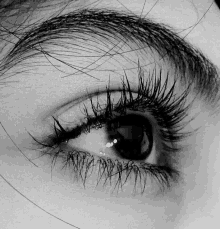 a black and white photo of a woman 's eye