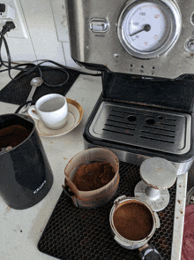 a krups coffee maker sits on a counter next to a cup and saucer