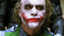 a close up of the joker 's face with blood on his lips