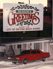 a red car is parked in front of a season 's greetings sign