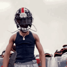 a man wearing a black football helmet with a red and white stripe