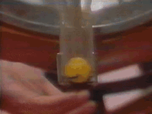 a close up of a person 's hand with a yellow object in the background