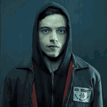 a man in a hooded jacket with a patch that says mr robot