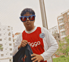 a man wearing sunglasses and a red and white shirt that says ziggo