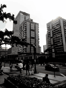 a black and white photo of people walking in front of a building that says ' the ritz carlton ' on it