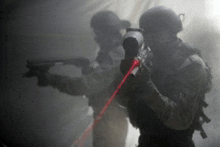 two soldiers are holding guns in a foggy room