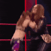 a female wrestler is being lifted in the air by another wrestler in a ring .