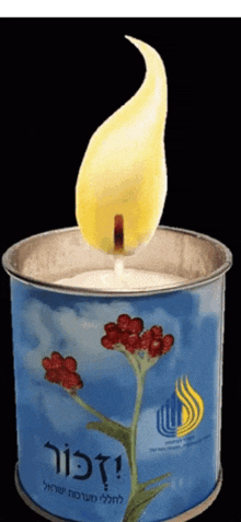 a candle in a blue can with a flower on it