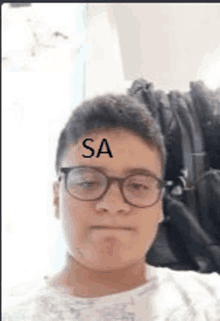 a young man wearing glasses has the word sa on his forehead .