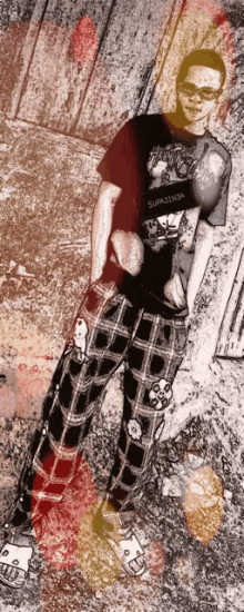 a man wearing plaid pants and a t-shirt that says ' supreme ' on it