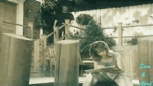 a woman sits on a porch reading a book with abc written on the bottom right