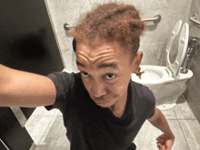 a man taking a selfie in a bathroom with a toilet